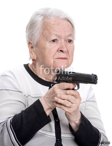 A stock photo of an old white woman with grey hair pointing a gun to the right of the frame.